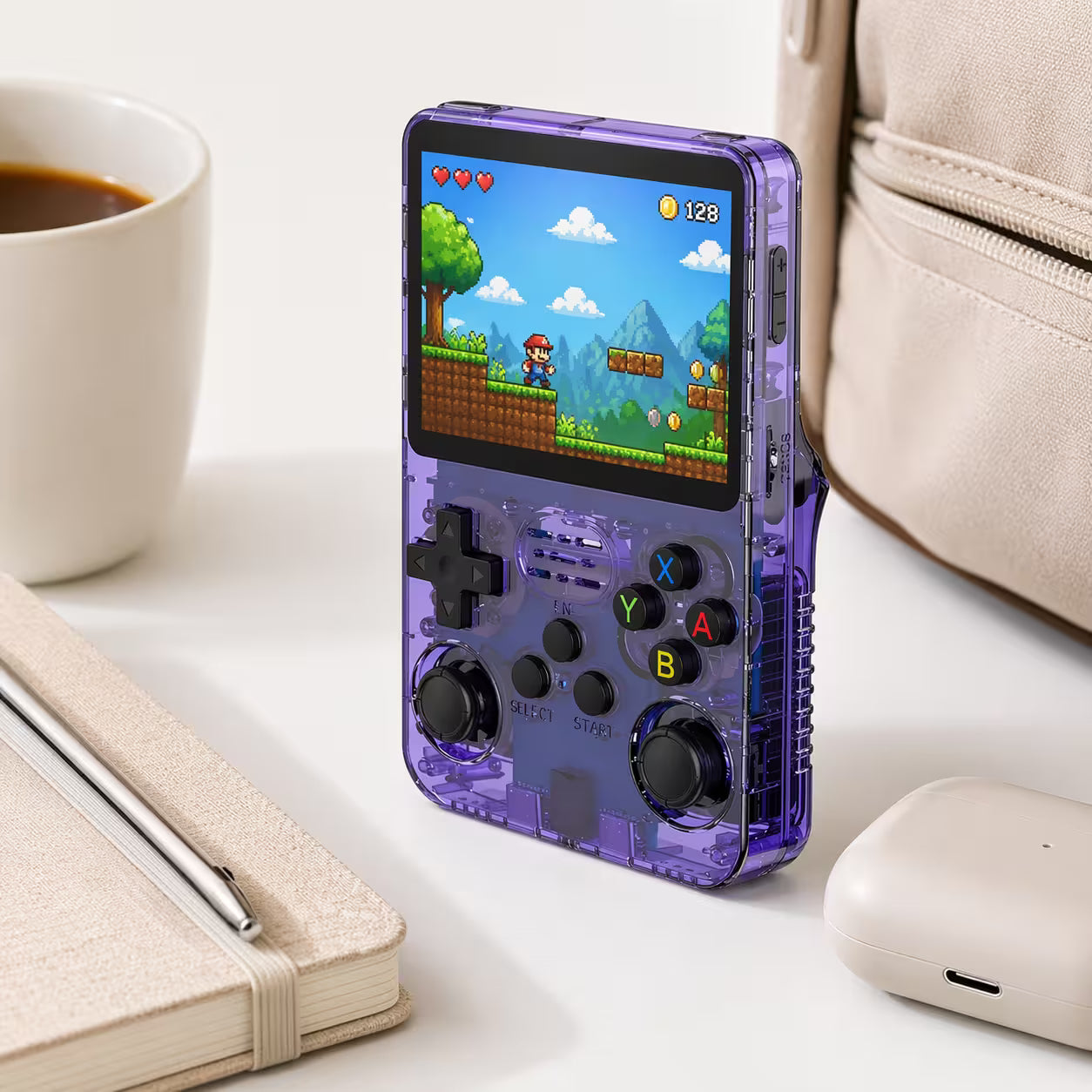 Compact iGameConsole retro handheld console beside everyday carry items, showing portable size, transparent purple shell, and a colorful pixel platform game screen.