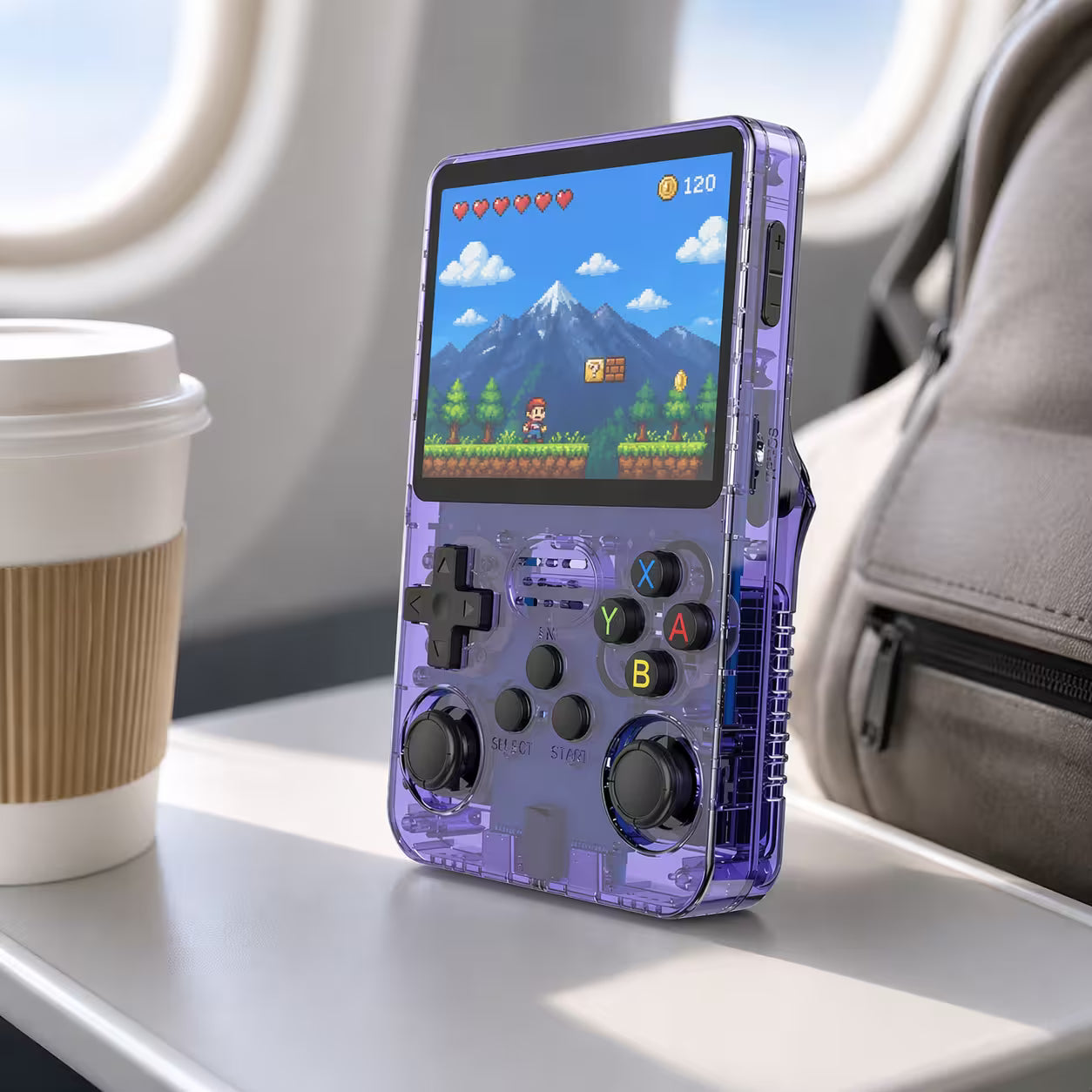 iGameConsole portable handheld game console on an airplane tray table with coffee and backpack, designed for retro gaming while traveling.