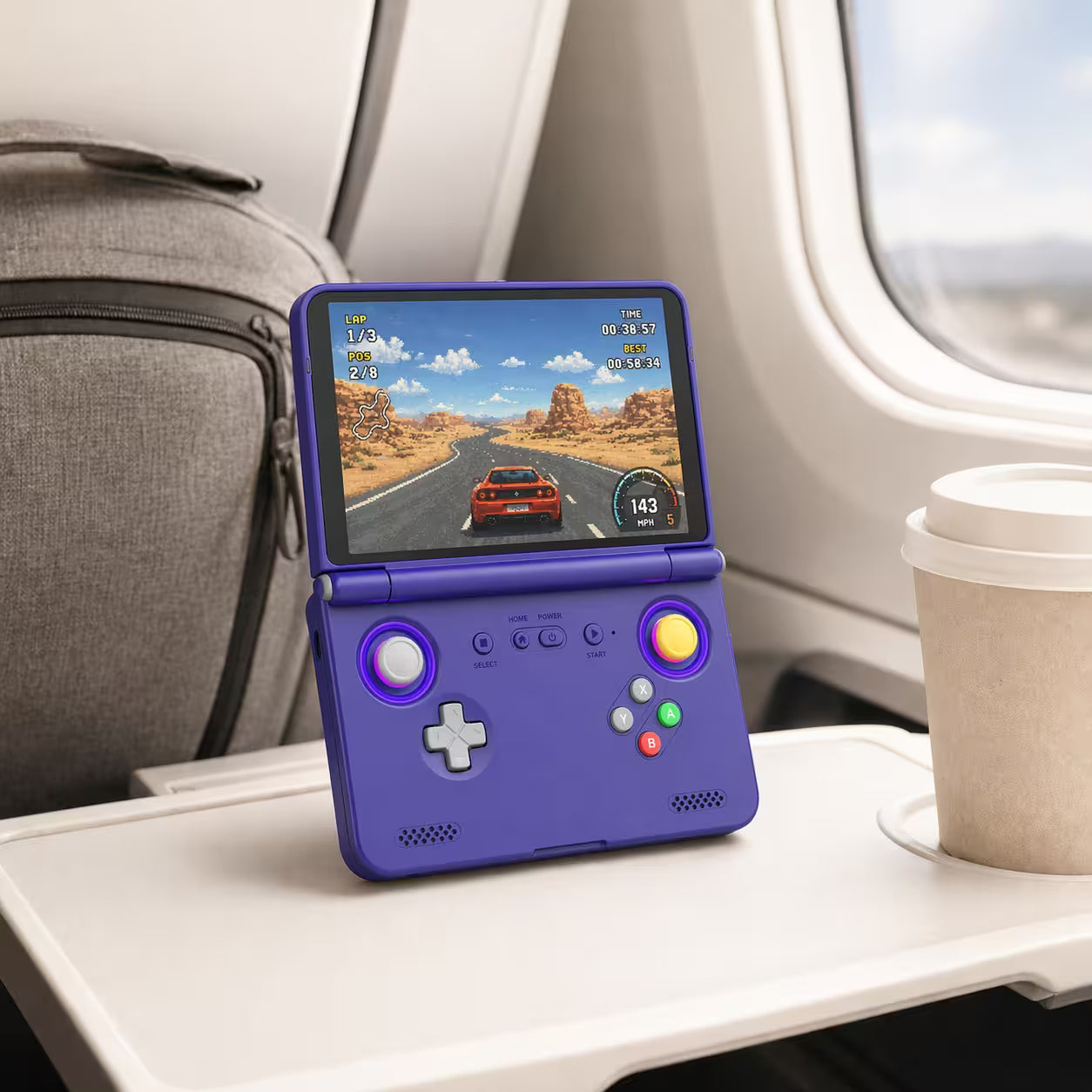 iGameConsole purple portable gaming console on an airplane tray table with a coffee cup and travel bag, showing retro gaming on the go.