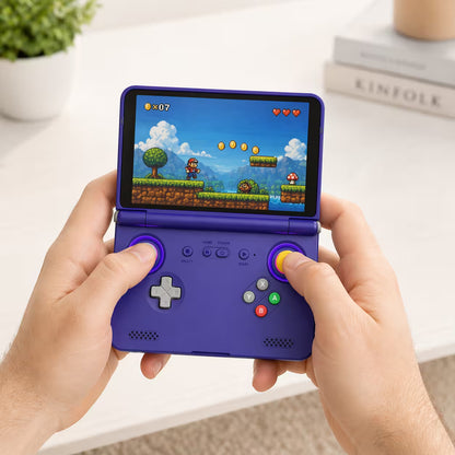 Adult hands holding the iGameConsole purple portable handheld game console, showing its compact clamshell design, comfortable controls, and colorful retro game screen.