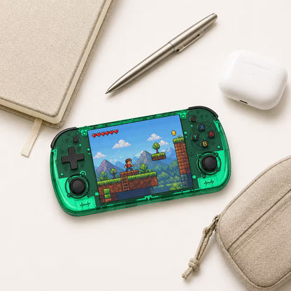 iGameConsole R36H Promax transparent green compact retro handheld console beside everyday carry items including a notebook, pen, earbuds case, and pouch, showing portable size and daily carry convenience.