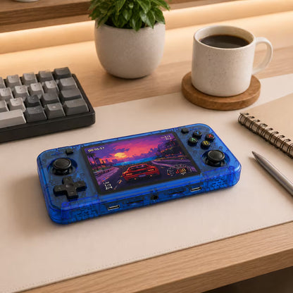iGameConsole R36H transparent blue retro portable console on a clean modern desk setup with a keyboard, coffee mug, notebook, and plant, displaying a colorful racing game screen.