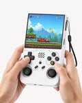 Adult hands holding the iGameConsole R36XX white portable handheld console, showing its compact vertical design, comfortable grip, black D-pad, dual joysticks, colorful ABXY buttons, and retro game screen.