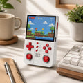 iGameConsole R40XX Pro Max white and red retro portable console on a clean modern desk setup with a keyboard, coffee mug, notebook, and plant, displaying a colorful retro platform game.