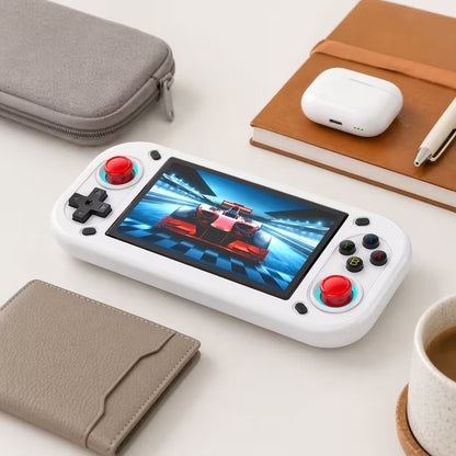 iGameConsole R43S white compact retro handheld console beside everyday carry items including a notebook, pen, earbuds case, and pouch, showing portable size and daily carry convenience.