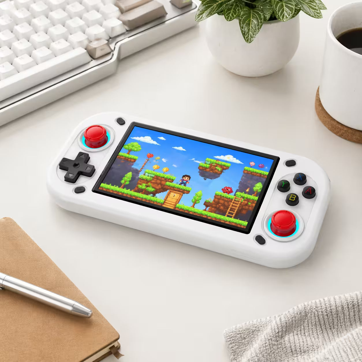 iGameConsole R43S white retro portable console on a clean modern desk setup with a keyboard, coffee mug, notebook, and plant, displaying a colorful retro game screen.