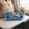 iGameConsole R46H transparent blue portable gaming console on an airplane tray table with a backpack and coffee cup, showing retro gaming on the go.