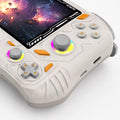 Close-up of the iGameConsole RG52 Pro Max off-white and orange handheld console showing the dual RGB-ring joysticks, gray D-pad, light gray ABXY buttons, orange accent buttons, screen edge, and shell details.