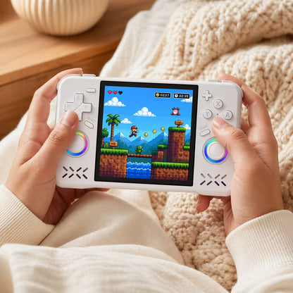 Adult hands holding the iGameConsole XF40H WiFi Pro white portable handheld console, showing its compact horizontal design, comfortable grip, dual RGB-ring joysticks, D-pad, and retro platform game screen.