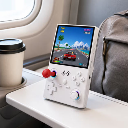 iGameConsole XF40V white portable gaming console on a travel tray table with a coffee cup and backpack, showing portable retro gaming on the go.